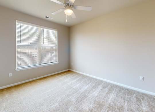 a bedroom with carpet and a ceiling fan