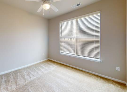 a bedroom with carpet and a ceiling fan