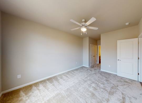 a bedroom with carpet and a ceiling fan