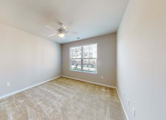 a bedroom with carpet and a ceiling fan