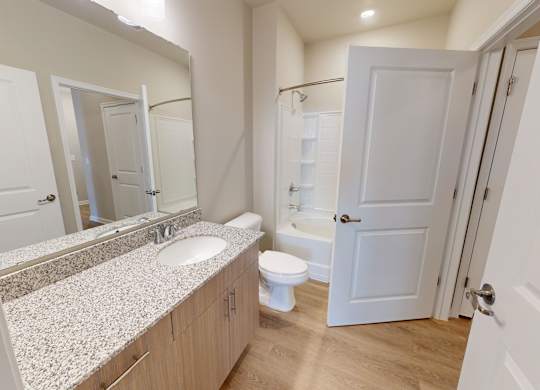 a bathroom with granite countertops and a tub