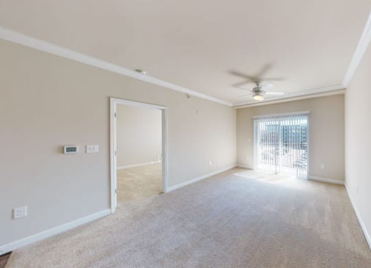 Living room with carpet; ceiling fan; door to patio