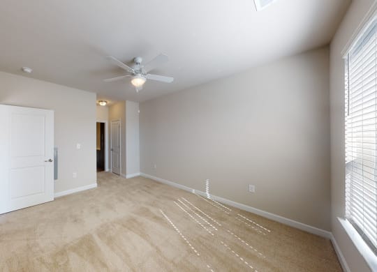 Bedroom with ceiling fan, carpet and door to bathroom