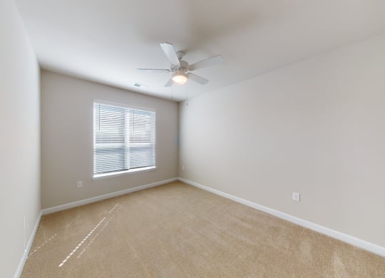 Bedroom with ceiling fan, carpet and door to bathroom