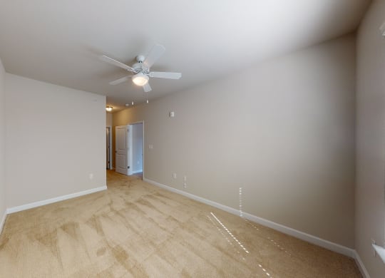 Bedroom with ceiling fan, carpet and door to bathroom