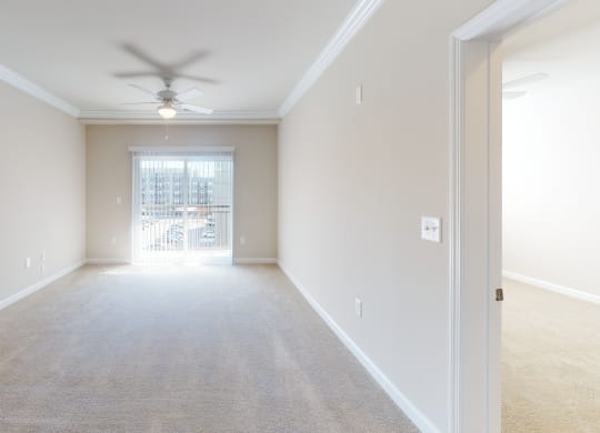 Living room with carpet; ceiling fan; door to patio