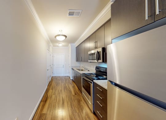 Kitchen with dark cabinets, granite countertops, vinyl wood plank floors