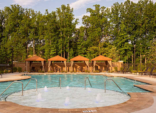 Pool With Cabanas and Chairs