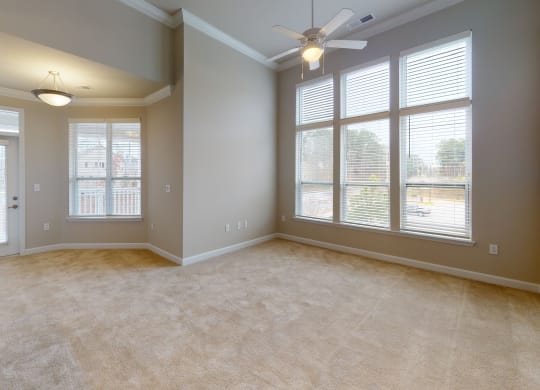 Living room with ceiling fan, high ceilings and door to balcony