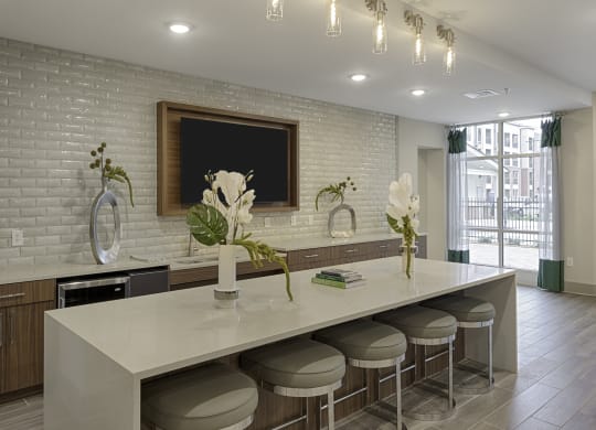 Clubhouse kitchen with island and seating, TV, mini fridge, and sink