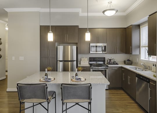 Kitchen with island, dark cabinets, vinyl floors and granite countertops