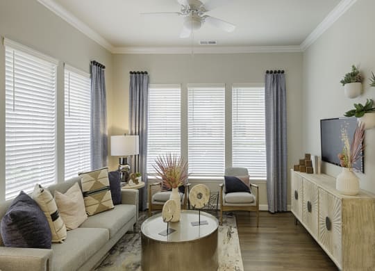 Living room with ceiling fan, high ceilings and vinyl plank floors