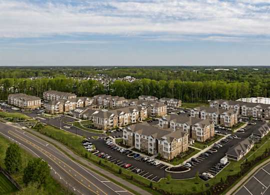 A large apartment complex with a parking lot in front.