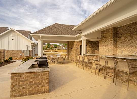 A patio area with a bar and chairs.