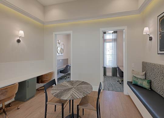 A dining table with four chairs is in the middle of a room with a bench and a window.