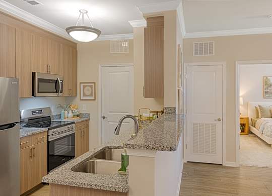 A kitchen with a granite counter top and a sink.