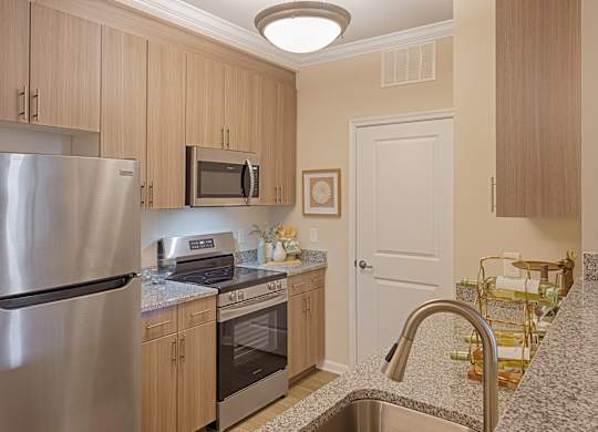 A kitchen with a stainless steel refrigerator and microwave.