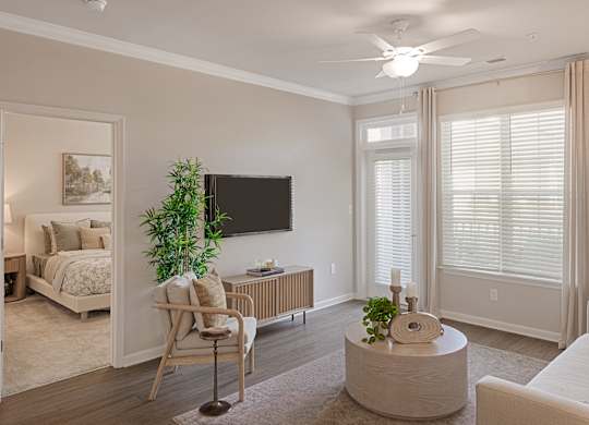 A living room with a chair, a table, and a television.