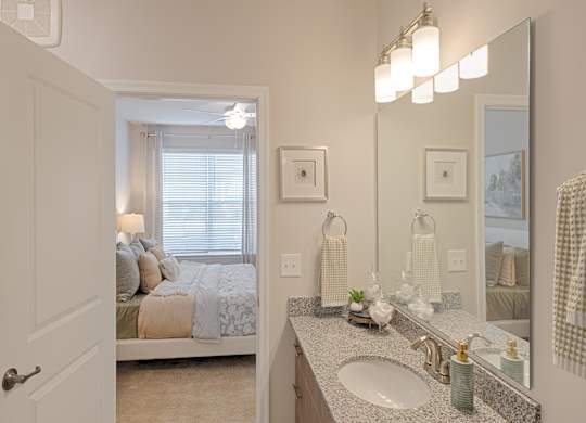 A bathroom with a bedroom view through the window.