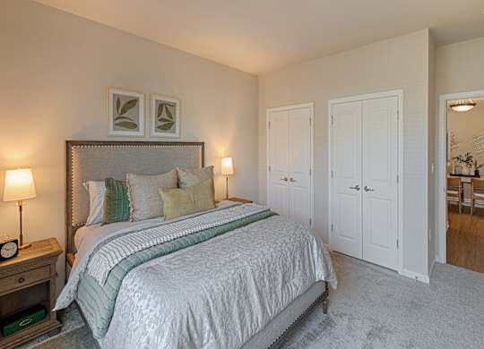 A bedroom with a large bed and a mirror on the wall.
