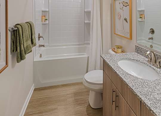A white bathroom with a toilet, sink, and bathtub.