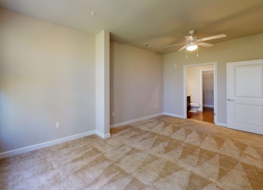 Bedroom with sunroom; carpet; ceiling fan, door to bathroom and closet