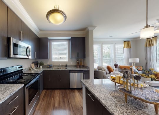 Kitchen with island, dark cabinets, vinyl floors and granite countertops