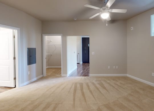 Bedroom with ceiling fan, carpet and door to bathroom