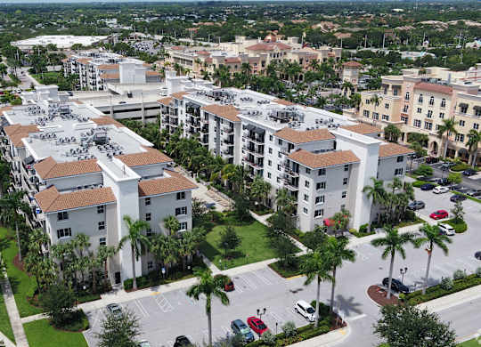 A large apartment complex surrounded by palm trees.