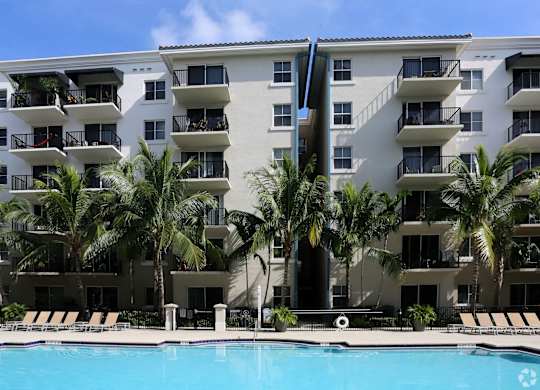 An apartment building with a pool in front of it.