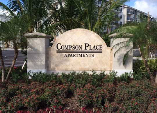 A sign that says Compson Place Apartments.