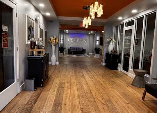 A long hallway with a wooden floor and a sofa.