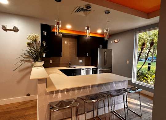 A kitchen area with a white counter top and black cabinets.