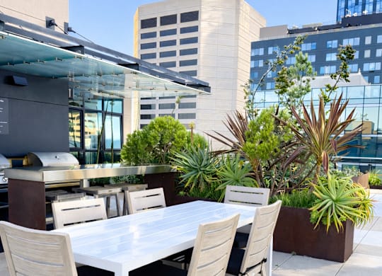 A white table with chairs is set up on a rooftop patio.