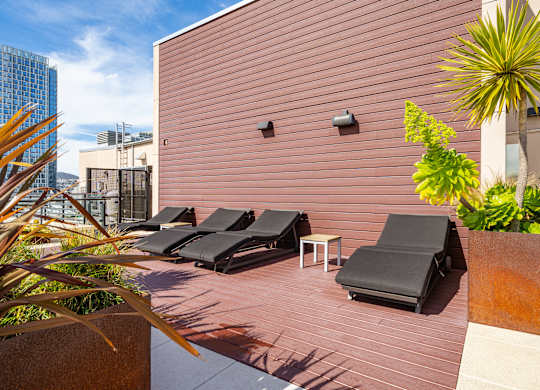 A patio with black chairs and a table.