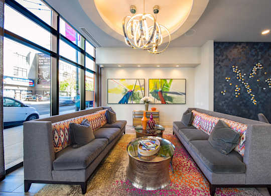 A living room with two grey couches, a coffee table, and a chandelier.