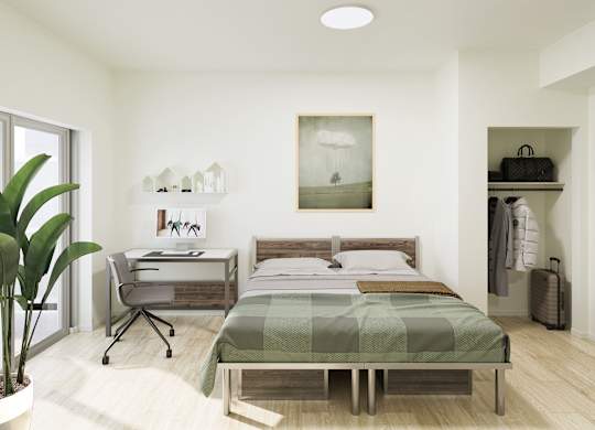 A bedroom with a bed, desk, and chair.