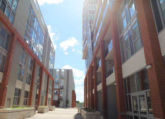 a city street with brick buildings and a blue sky