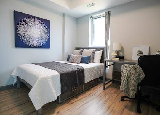 a bedroom with a bed and a desk with a chair