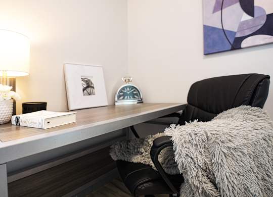 a desk with a lamp and a chair in a room