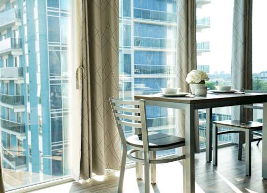 a room with a table and chairs in front of a window