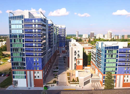 an aerial view of a cluster of buildings with a city in the background