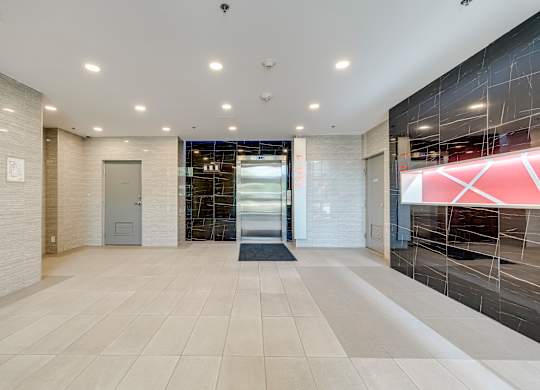 A hallway with a tiled floor and a glass door.