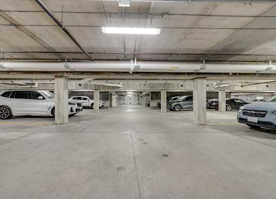 A parking garage with multiple cars parked.