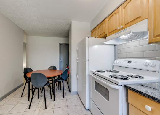 A kitchen with a table and chairs.