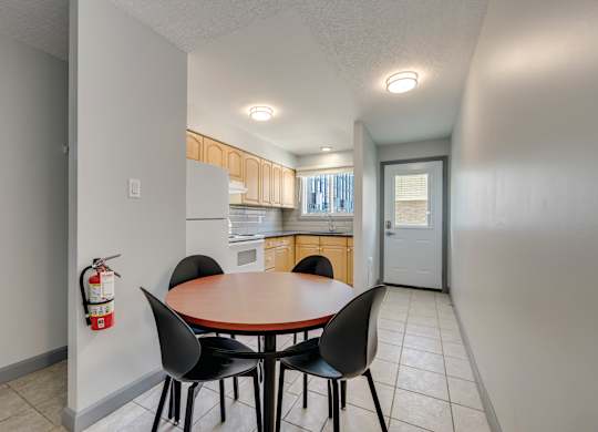 A dining room with a table and chairs.