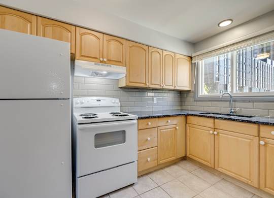 A kitchen with wooden cabinets and a white refrigerator.