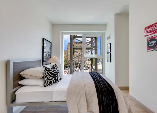 A bedroom with a bed, pillows, and a blanket.