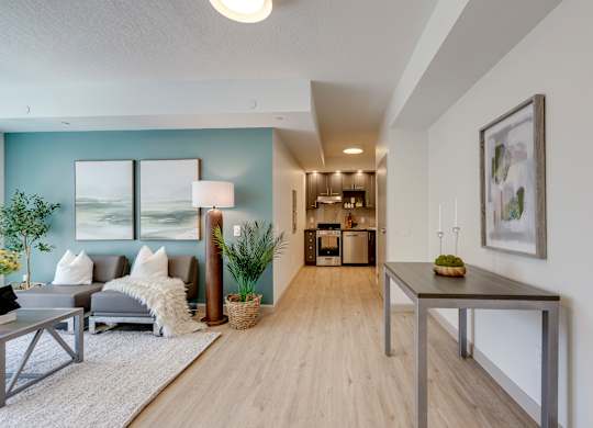 A modern living room with a grey sofa, a coffee table, and a dining table.