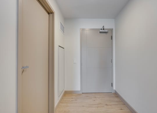A white door is in the middle of a hallway.